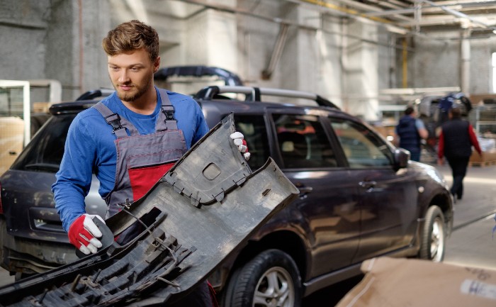 mechanic-with-car-bumper-in-a-workshop-PWWDH93 (1)